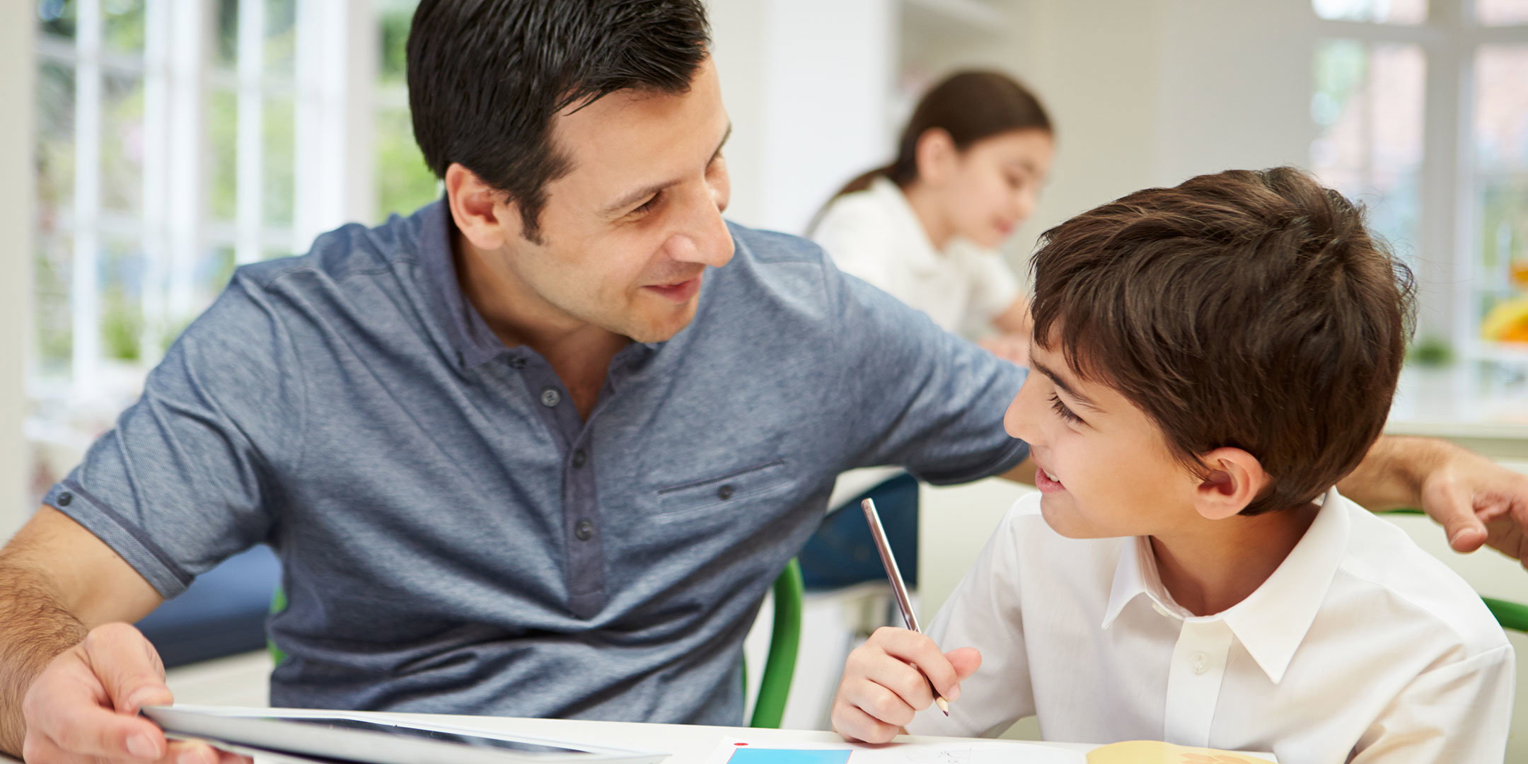 Man helping boy with homework